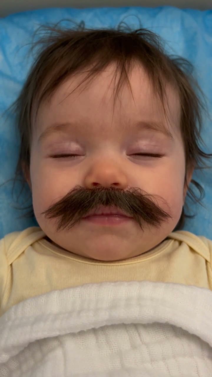 Baby With Mustache AI result preview — A swaddled newborn opens its eyes, yawns and turns toward the phone camera while an oversized mustache makes…